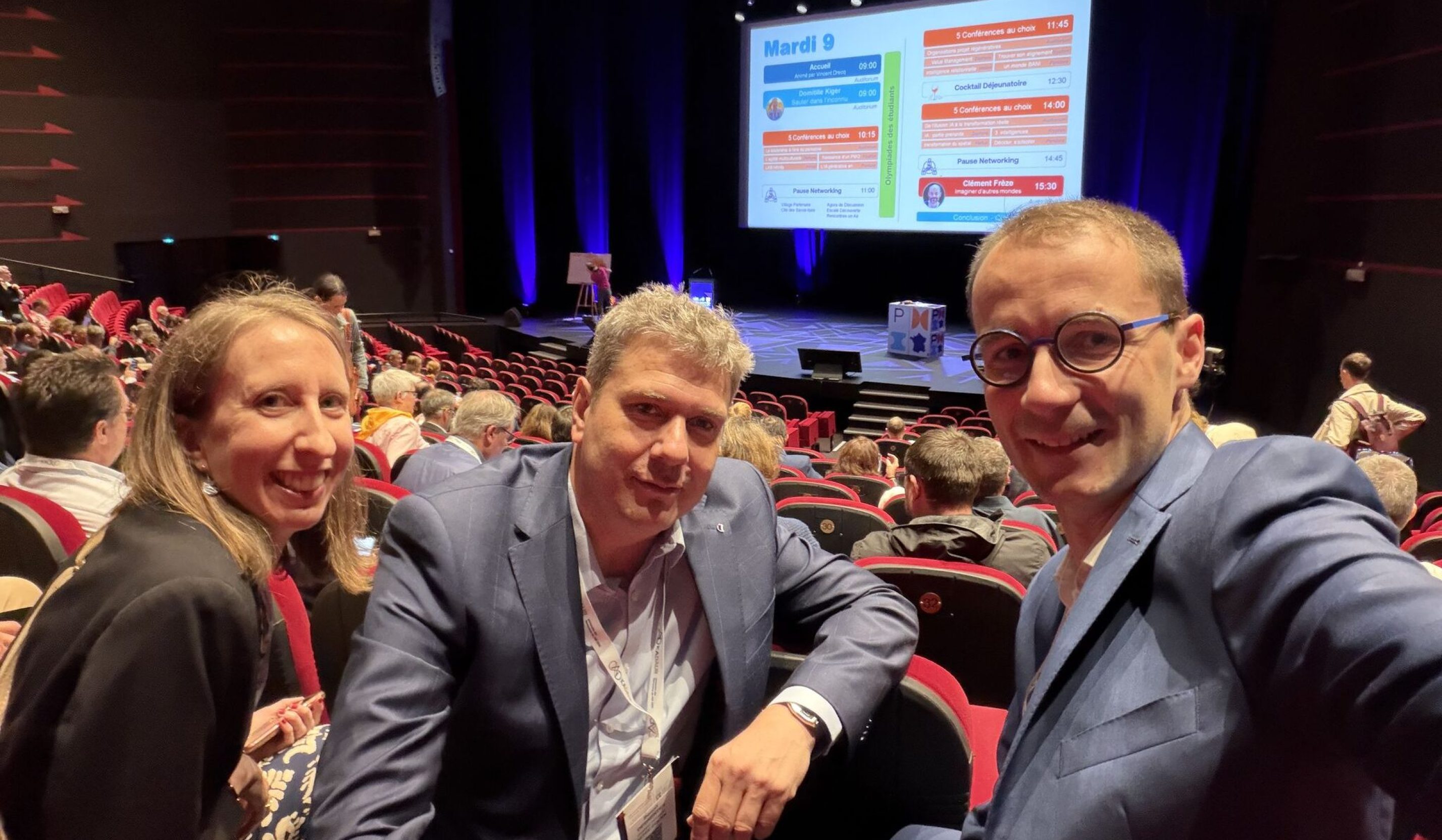 Selfie of three persons attending to a conference.